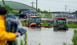 　大雨で水に漬かった農業用車両＝１１日午後１時４３分、熊本県玉名市