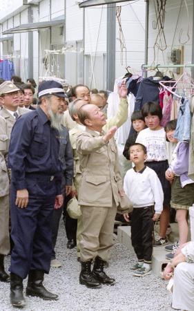 　１９９２年３月、仮設住宅の視察に訪れた宮沢喜一首相（中央）を案内する鐘ケ江管一島原市長（左）＝長崎県島原市