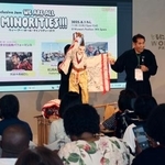 　徳島の人形芝居「阿波木偶箱まわし」の歴史を説明する保存会顧問の辻本一英さん（奥右）＝１日午後、大阪市此花区の夢洲
