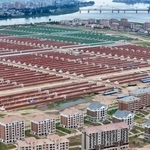 　中朝国境の鴨緑江（奥）に面して建てられた住宅と建設中の大規模温室農場。１日に北朝鮮の金正恩朝鮮労働党総書記が視察した＝北朝鮮北西部・新義州（朝鮮中央通信＝共同）