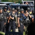 　８日、米南部アトランタにある疾病対策センター（ＣＤＣ）の施設で、銃撃事件の対応に当たる警察官ら（ゲッティ＝共同）
