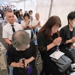 　「京橋駅空襲」から８０年となり、ＪＲ京橋駅前で営まれた慰霊祭で、犠牲者を追悼する参列者たち＝１４日午前、大阪市