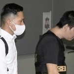 　カンボジアから移送され、中部空港に到着した容疑者（右）＝２０日