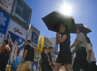　猛暑日となった大阪・ミナミの繁華街で、日傘を差して歩く人たち。気象庁は夏（６～８月）の平均気温が１８９８年の統計開始以降で最高になったと発表した＝１日午後