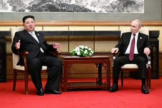 するロシアのプーチン大統領（右）と北朝鮮の金正恩朝鮮労働党総書記＝３日、北京（タス＝共同）