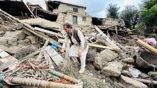 　地震で壊れた家屋と男性＝２日、アフガニスタン・クナール州（ゲッティ＝共同）