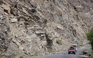 　アフガニスタン東部クナール州ヌールガルで、落石を避けて通る車＝５日（共同）