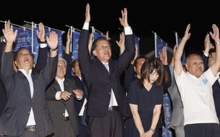 　茨城県東海村長選で４選を果たし、万歳する山田修氏（中央）＝７日午後、茨城県東海村