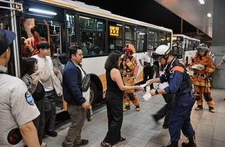 　関西空港に緊急着陸したユナイテッド航空機から避難し、バスで誘導される乗客＝１２日午後８時５８分