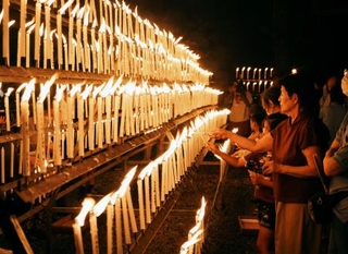 　光三宝荒神社の「献灯祭」でろうそくに火をともす参拝者ら＝１３日夜、和歌山県橋本市