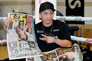 　試合から一夜明け、スポーツ新聞を手にポーズをとる井上尚弥＝１５日、横浜市