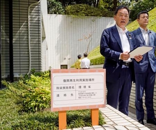 　福島県内の除染で発生した土を用いた、環境省が入る庁舎の花壇を視察する浅尾環境相（左）＝１６日午前、東京都千代田区