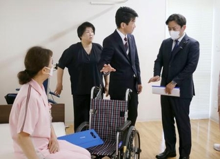 　特別養護老人ホーム「サンシティ北条」で、介護の取り組みについて説明を受ける福岡厚労相（右端）＝１６日午後、松山市