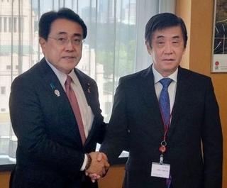 　赤沢経済再生相（左）と握手する日本自動車工業会の片山正則会長＝１７日午前、東京都千代田区