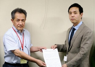 　厚労省の担当者（右）に要望書を手渡す「医療情報の公開・開示を求める市民の会」の関係者＝１９日午後、東京・霞が関