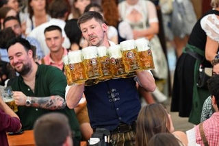 　ビールジョッキを運ぶウエーター＝２０日、ドイツ・ミュンヘン（ロイター＝共同）