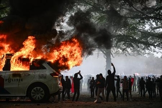 　オランダ西部ハーグで２０日、反移民デモが過激化。警察車両が燃やされた（ゲッティ＝共同）