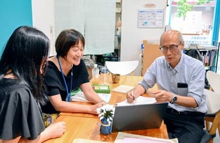 　韓国文化を学ぶ地域クラブ発足に向けてスタッフと打ち合わせをする金シニョンさん（右）＝８月、神戸市長田区