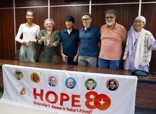 　記者会見を終え、記念撮影に応じる東条英利さん（左から３人目）、クリフトン・トルーマンさん（同４人目）ら＝２２日午後、京都市左京区