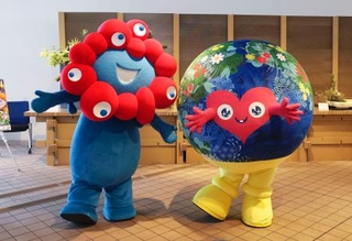 　大阪・関西万博会場に登場した国際園芸博覧会のマスコットキャラクター「トゥンクトゥンク」（右）＝２３日、大阪市此花区の夢洲