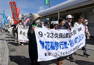 　核廃絶を訴えながら、久保山愛吉さんの墓がある寺へ行進する集会の参加者＝２３日午前、静岡県焼津市