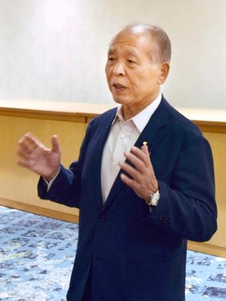 　自民党総裁選の対応について、記者団の取材に応じる鈴木宗男参院議員＝２３日午後、札幌市