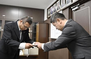 　６月、香川県東かがわ市議会に申し入れを行う上村一郎市長。左は山口大輔副議長＝香川県東かがわ市