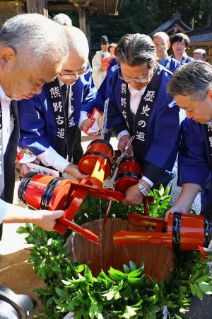 　熊野本宮大社の「献湯祭」で本殿前の大だるに温泉の湯を注ぎ入れる宿泊施設の代表者ら＝２７日午前、和歌山県田辺市