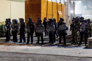 　トランプ大統領の移民政策に抗議するデモの警備に当たるＩＣＥ施設の職員＝９月１日、ポートランド（ロイター＝共同）