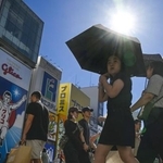 　猛暑日となった大阪・ミナミの繁華街で、日傘を差して歩く人たち。気象庁は夏（６～８月）の平均気温が１８９８年の統計開始以降で最高になったと発表した＝１日午後