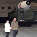 　２０２２年１１月、北朝鮮の国営メディアに初登場した金正恩朝鮮労働党総書記（右）の娘。奥はＩＣＢＭ「火星１７」＝平壌国際空港（朝鮮中央通信＝共同）