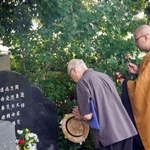 　関東大震災時に虐殺された姜大興さんの墓前で手を合わせる人＝４日午後、さいたま市見沼区