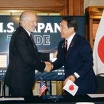 　日米関税合意に関する文書に署名し、握手する赤沢経済再生相（右）とラトニック米商務長官＝４日、ワシントン（共同）