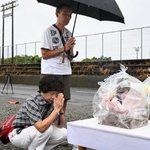 　園の駐車場に設けられた献花台に手を合わせる夫婦＝５日午前、静岡県牧之原市