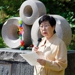 　慰霊碑の前であいさつする日弁連の渕上玲子会長＝７日午前、長野県大町市