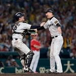　リーグ優勝を決め、抱き合う阪神の岩崎（右）と坂本のバッテリー＝甲子園