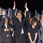 　茨城県東海村長選で４選を果たし、万歳する山田修氏（中央）＝７日午後、茨城県東海村