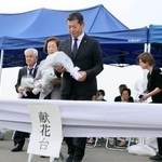 　決壊現場での追悼式で献花する神達岳志市長（中央）ら＝１０日午後、茨城県常総市