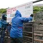 　富士山の登山道を冬季閉鎖するため、看板を設置する作業員＝１０日午後、静岡県富士宮市