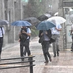 　大雨の中、傘を差して歩く人たち＝１１日午後３時３４分、東京都中央区