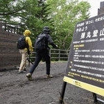 　２０２４年６月、富士山の山開きを前に山梨県側から登山に向かう人たちヘ「弾丸登山」の注意を呼びかける看板