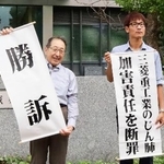 　控訴審判決を受け、「勝訴」などと書かれた紙を掲げる原告側弁護士ら＝１１日午後、福岡高裁前