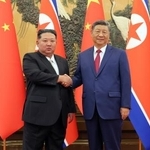 　握手する中国の習近平国家主席（右）と北朝鮮の金正恩朝鮮労働党総書記＝４日、北京（朝鮮中央通信＝共同）