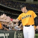 　ファンとタッチを交わす巨人・岡本＝８月東京ドーム