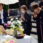 　作業員６７人が犠牲となった炭鉱事故の慰霊祭で、献花台に手を合わせる遺族ら＝１５日午後、福岡県川崎町