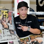 　試合から一夜明け、スポーツ新聞を手にポーズをとる井上尚弥＝１５日、横浜市
