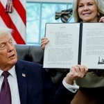 　ホワイトハウスで署名した覚書を誇示するトランプ米大統領＝１５日、ワシントン（ロイター＝共同）