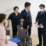 　特別養護老人ホーム「サンシティ北条」で、介護の取り組みについて説明を受ける福岡厚労相（右端）＝１６日午後、松山市