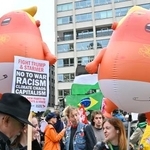 　トランプ米大統領を赤ちゃんに見立てた風船と、抗議デモに参加する人々＝１７日、ロンドン（共同）