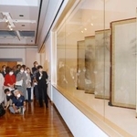 　再開する石川県七尾美術館の内覧会で、学芸員から国宝「松林図屏風」の説明を聞く参加者＝１９日午後、七尾市